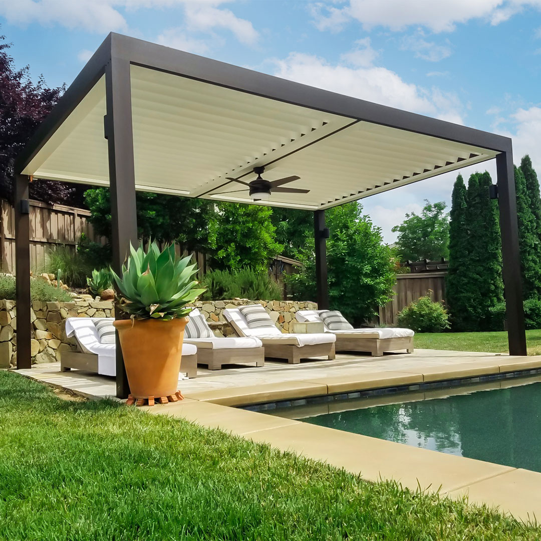 Poolside motorized louvered pergola providing shade over lounge chairs with a ceiling fan for added comfort.