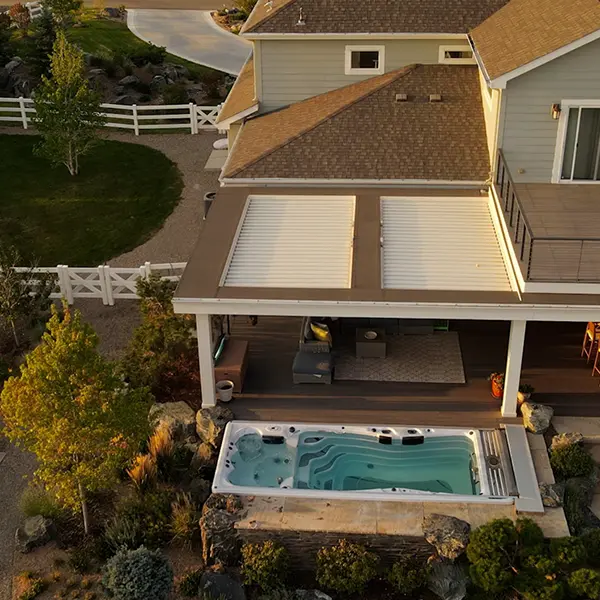 Pergola providing shade over an outdoor seating area with a hot tub nearby.